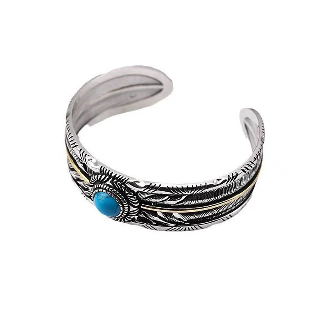 Two-tone feather cuff with a turquoise center stone, side view showing the open band