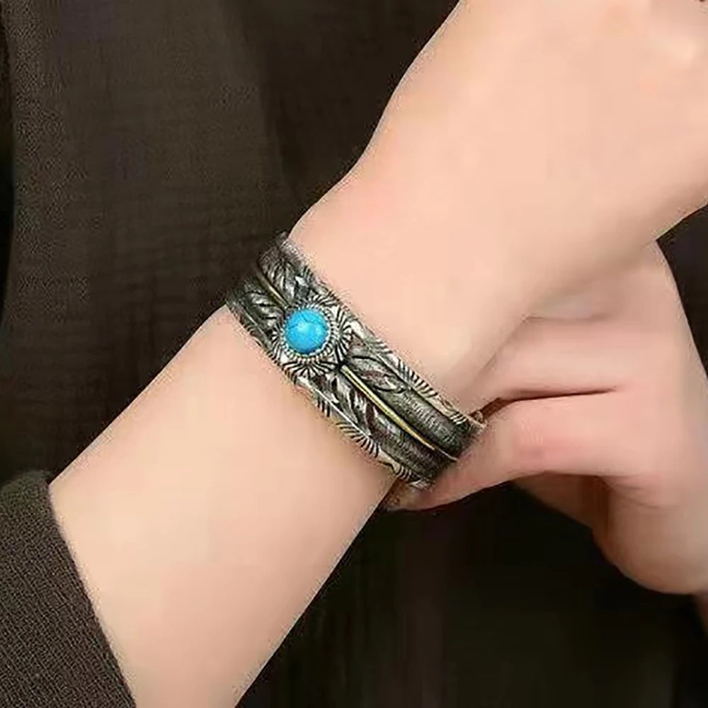 Two-tone feather turquoise cuff worn on the wrist