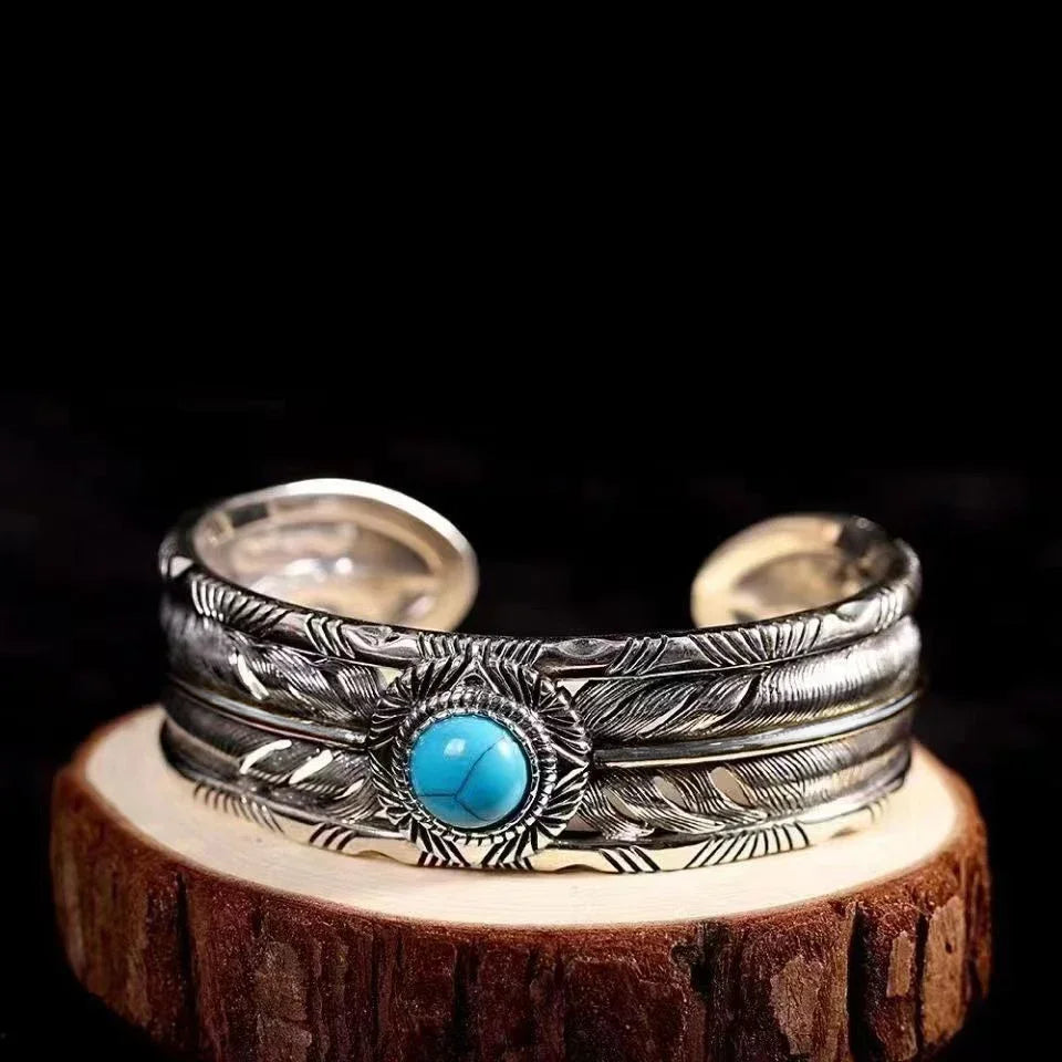 Front view of the turquoise feather silver cuff with its carved feather bands