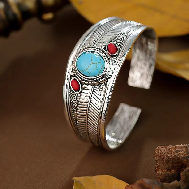 Side view of the silver feather cuff with turquoise and coral stones